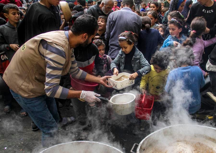 เด็ก-ผู้ใหญ่ชาวปาเลสไตน์ ถือภาชนะรับอาหารในกาซา