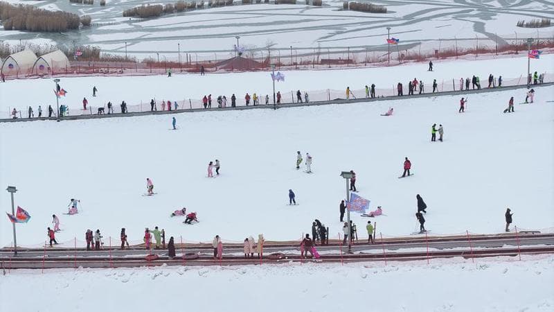 ผู้คนหลากวัยเล่นสนุกกลางลานสกีในอิ๋นชวน