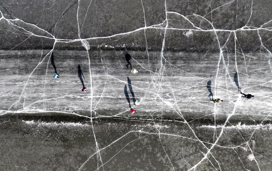 ผู้คน 'เล่นสเก็ต' ทอดเงาบนลานน้ำแข็งแตกลายในเสิ่นหยาง