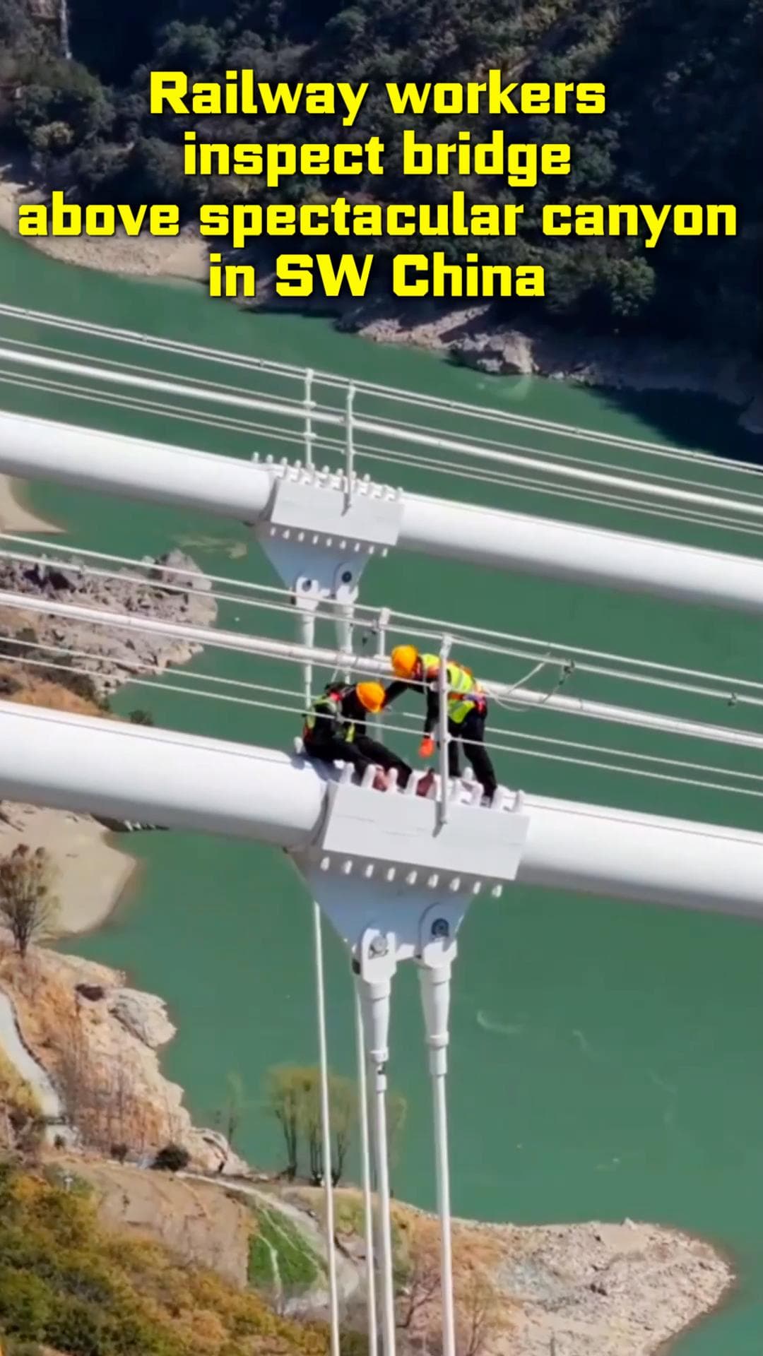 ทีมพนักงานปีนไต่ตรวจ ‘สะพานม้าเหล็ก’ ข้ามหุบเขางามในยูนนาน